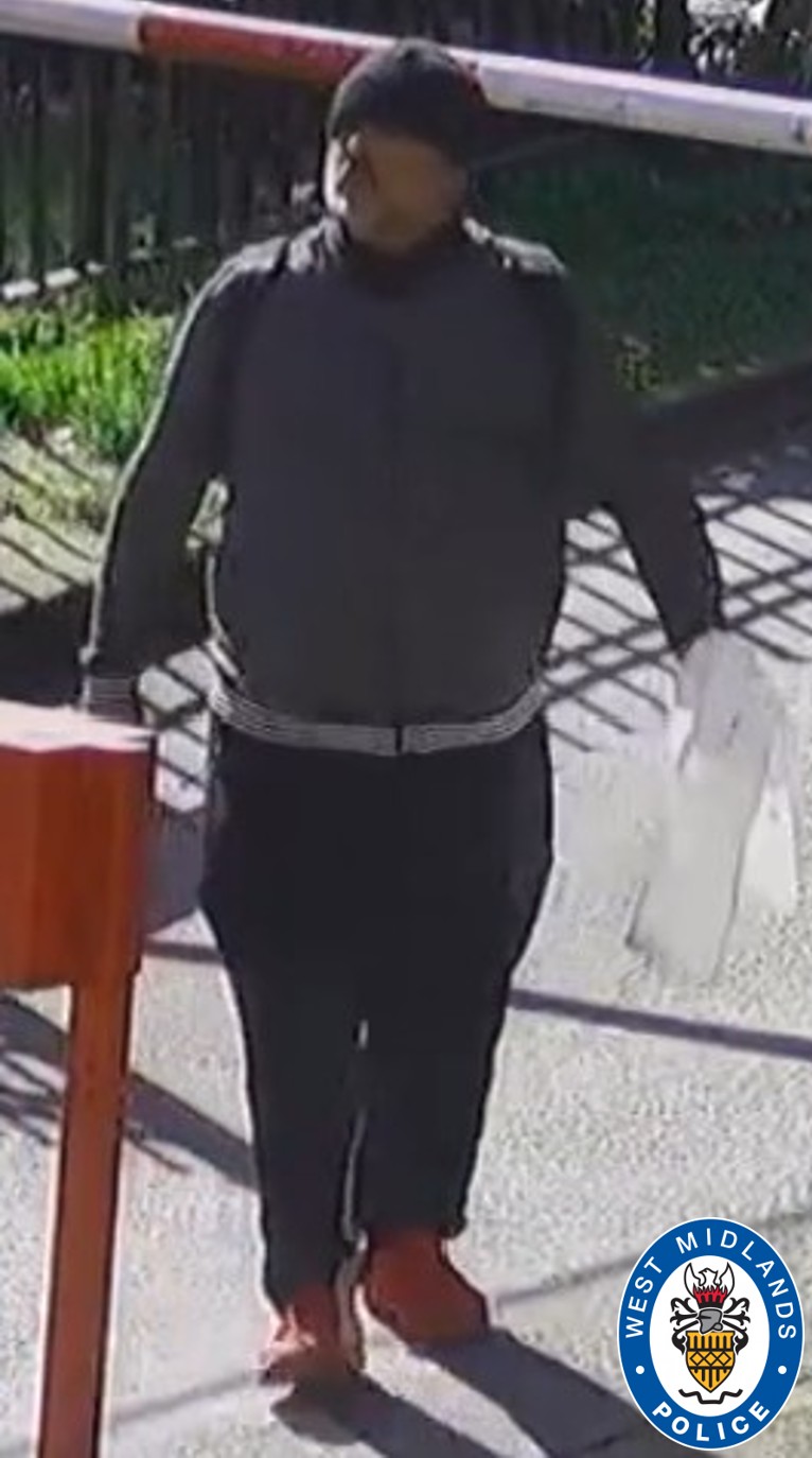 CCTV image of man in street wearing dark jacket, black hat and red trainers