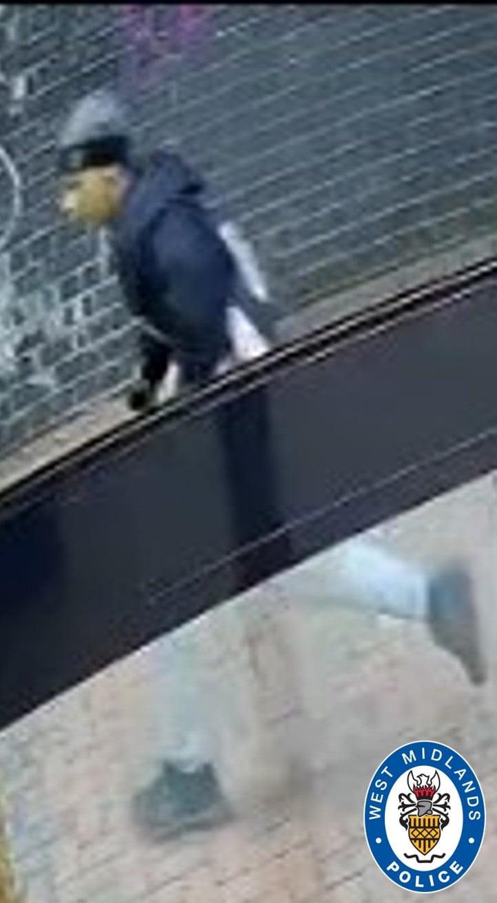 CCTV image showing man wearing a hat and tracksuit walking in street