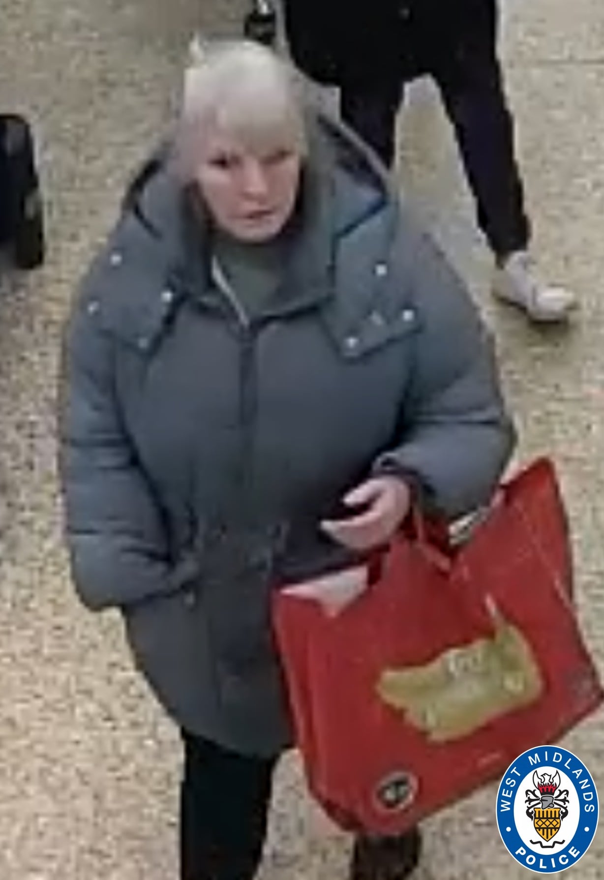 CCTV images of woman in a grey coat carrying a red shopping bag 